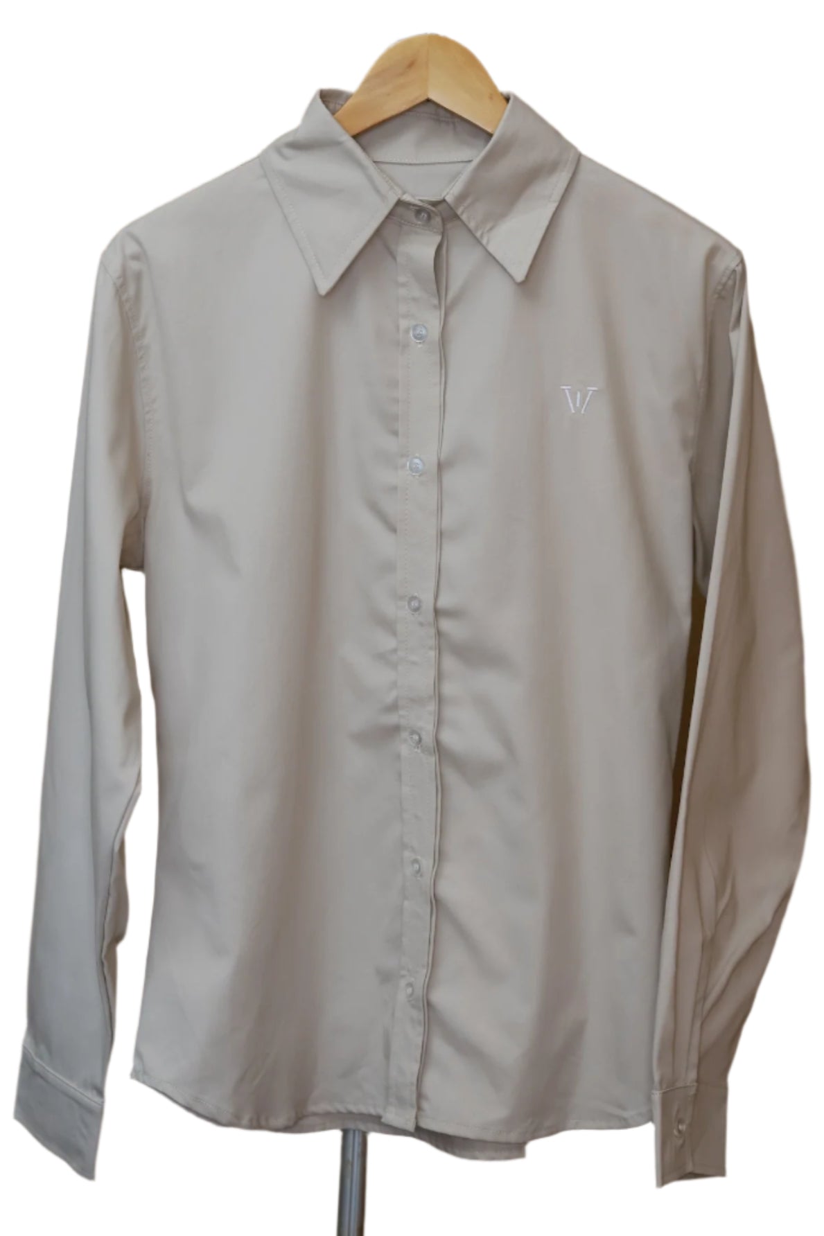 Beige shirt on a hanger against a brown wall