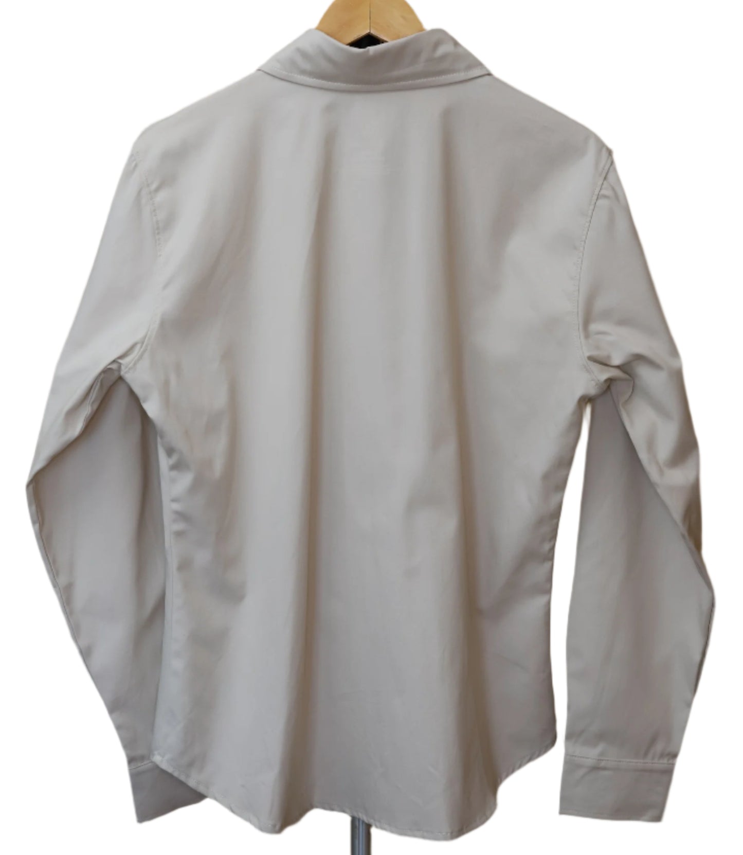 White shirt on a hanger against a beige wall