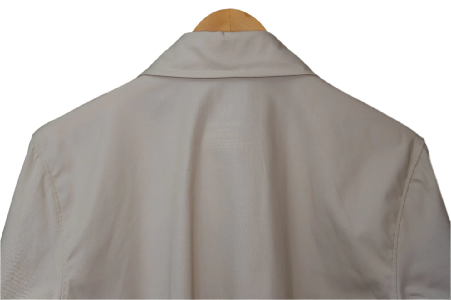 Light-colored shirt on a wooden hanger against a brown background