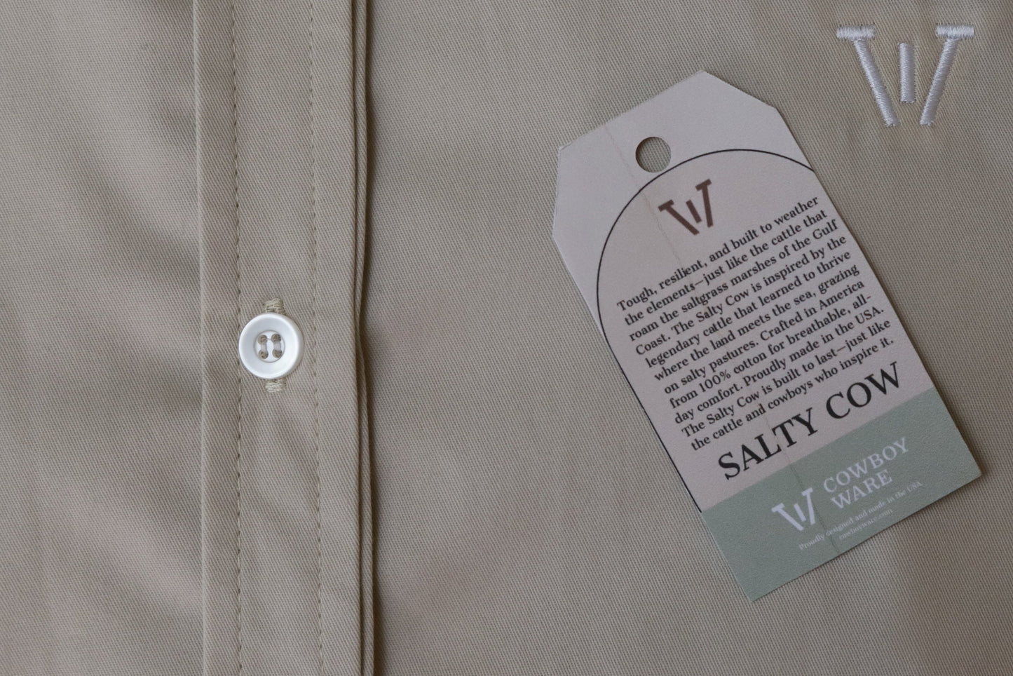 Close-up of a beige shirt with a 'Salty Cow' label on a light background