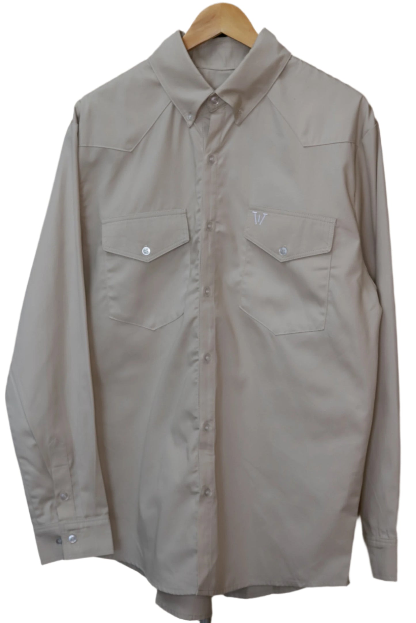 Beige shirt on a hanger against a brown background