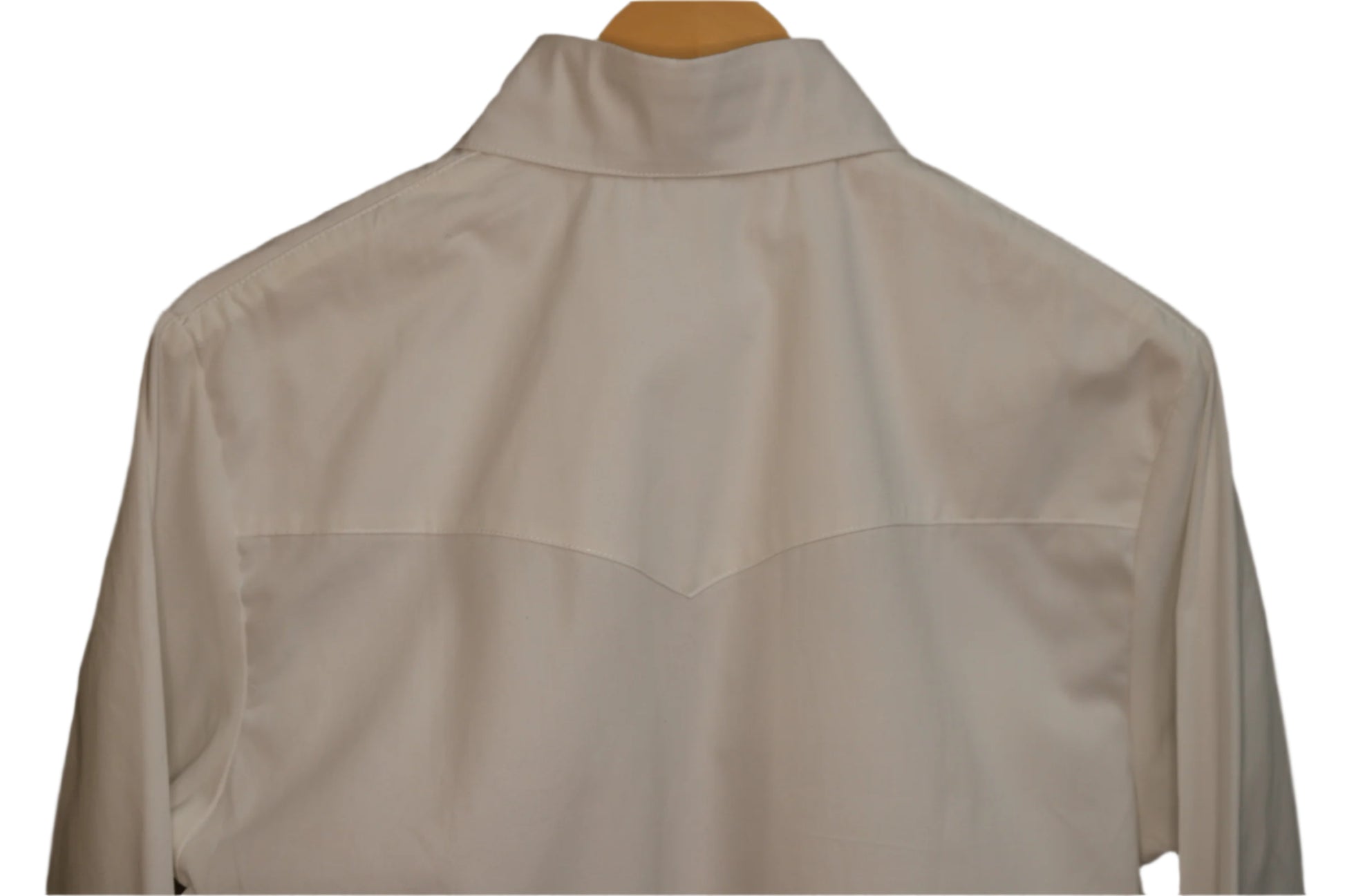 White shirt on a hanger against a brown background