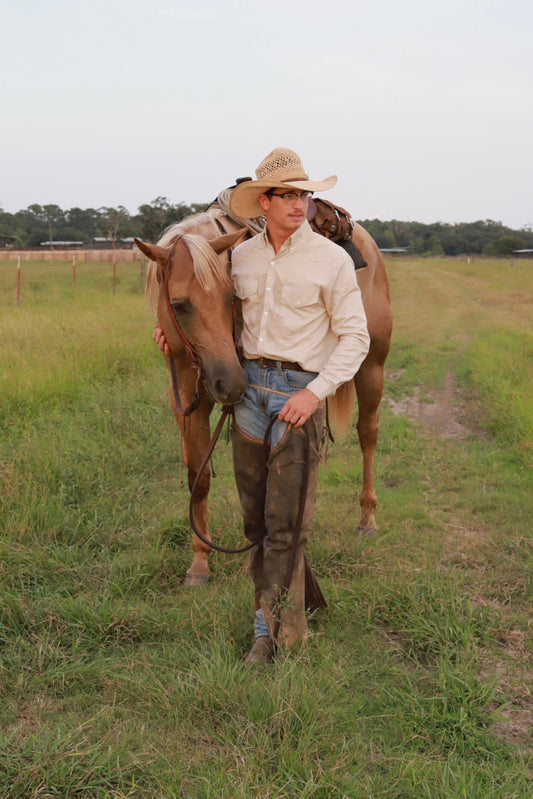 Man walking with a horse in a grassy field
